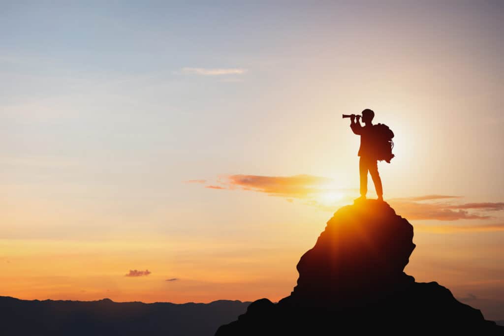 imagery of a man standing on top of a rock symbolizing searching for an addiction treatment program