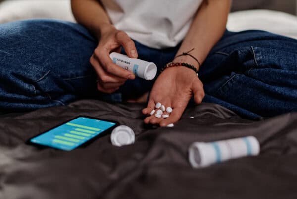 Focus on hands of a depressed teenage girl scattering pills on palm from small plastic bottle. Valium Addiction: Can You Get Addicted to Valium?