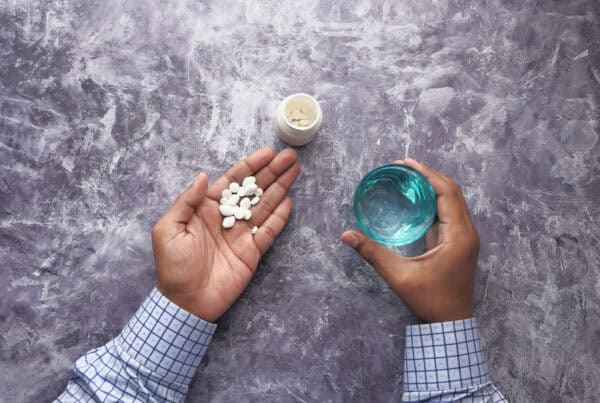 Top view of young person taking pills. The Physical Effects Of Xanax: Consequences, Risks, and Misconceptions