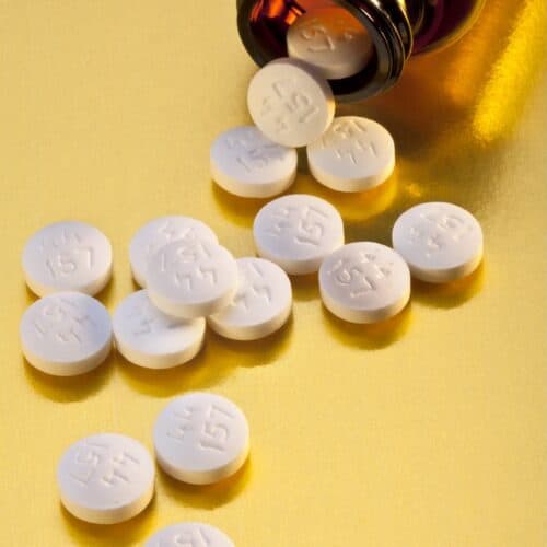 Prescription pills or tablets spilling from a medicine bottle.