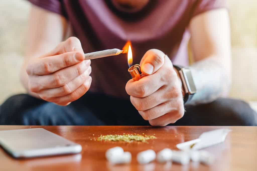 Canabis cigarrete and lighter in hand.