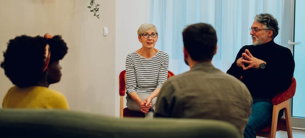 Portrait of a diverse group of patients gathered in circle at intensive outpatient program 